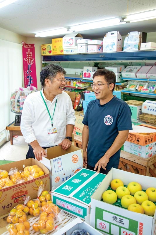 創業100年を超える〈古川青果〉の店主とともに。上田さん曰く「あの人は釣りの達人」とのこと。地域の頼れる存在だ