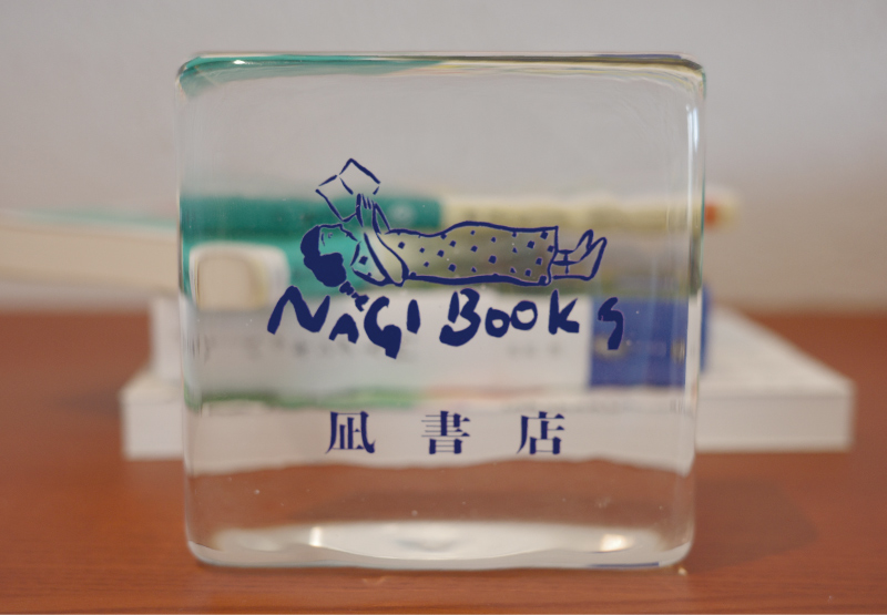 梅雨限定宿泊プラン「凪書店」のロゴが入った透明なブックスタンド