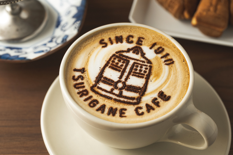 釣鐘のラテアートが描かれたTSURIGANE CAFEのオリジナルラテ